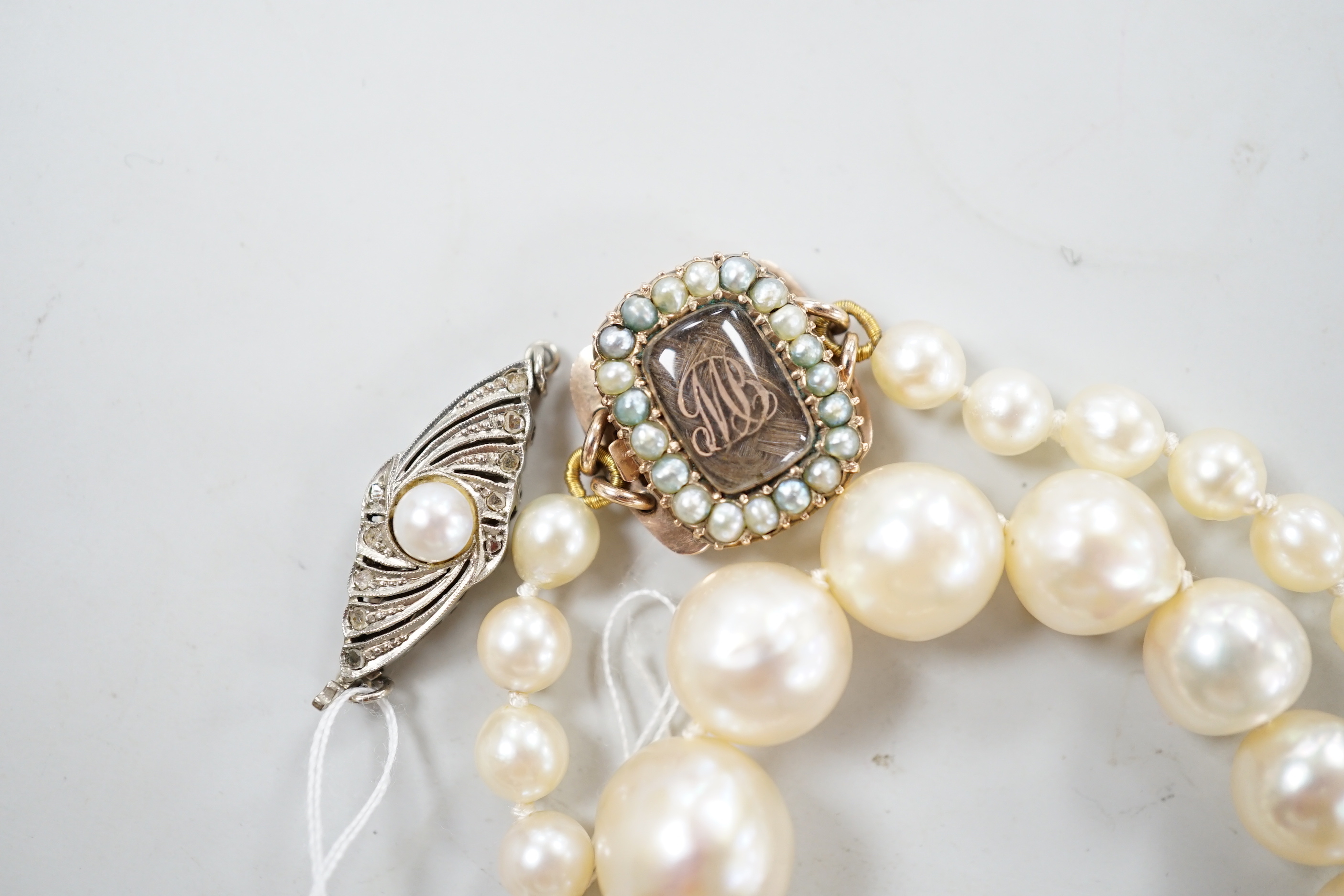 A single strand graduated cultured pearl necklace, now with an earlier 19th century seed pearl and plaited hair set clasp, 76cm, together with original clasp.